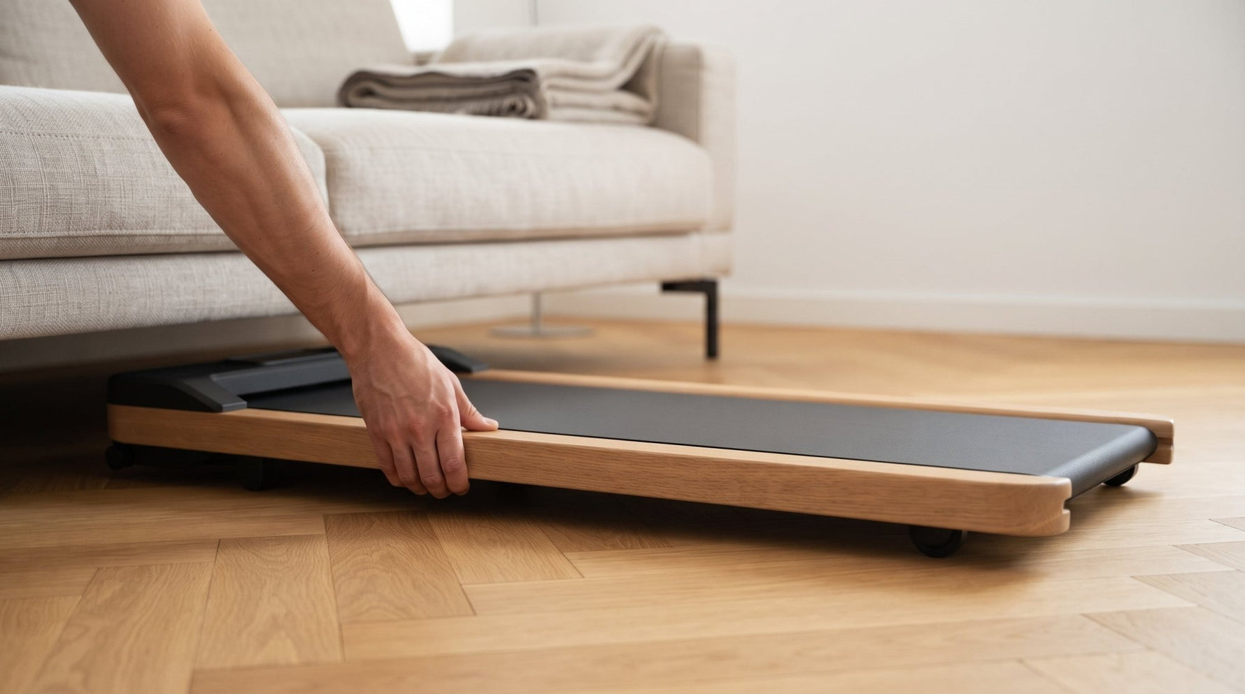 Walking Pad aus Eichenholz wird auf Transportrollen unter das Sofa geschoben