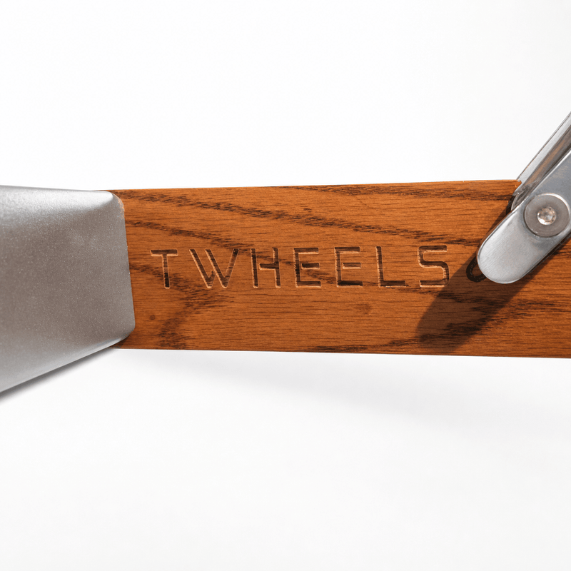 Detail der eingravierten TWHEELS Wortmarke im Roteichenrahmen der Premium-Hantelbank.
